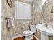 Charming powder room with unique wallpaper, pedestal sink, and bright natural light at 994 Debordieu Blvd., Georgetown, SC 29440