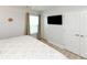 Bedroom features a large tv, wood flooring, and a bright window with curtains at 114-B 7Th Ave. N, Surfside Beach, SC 29575