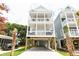Charming elevated beach house featuring a white exterior, multiple decks and ample parking at 114-B 7Th Ave. N, Surfside Beach, SC 29575