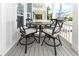 Outdoor seating with a wooden table and four cushioned chairs on covered porch at 114-B 7Th Ave. N, Surfside Beach, SC 29575