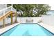 Backyard rectangular pool featuring a white vinyl privacy fence, lounge furniture, and mature trees at 114-B 7Th Ave. N, Surfside Beach, SC 29575