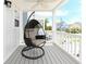 Cozy covered porch featuring a hanging swing chair with seating overlooking the neighborhood at 114-B 7Th Ave. N, Surfside Beach, SC 29575