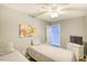 Bright bedroom features two twin beds, ceiling fan, a television, and colorful art at 1210 N Ocean Blvd. # 202, Surfside Beach, SC 29575