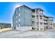 Exterior view of building featuring multi-level decks and parking area at 1210 N Ocean Blvd. # 202, Surfside Beach, SC 29575