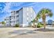 Exterior elevation featuring side of building and lush tropical landscaping at 1210 N Ocean Blvd. # 202, Surfside Beach, SC 29575