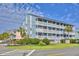 Multi-level condo building with white balconies and manicured landscaping near the ocean at 1210 N Ocean Blvd. # 202, Surfside Beach, SC 29575