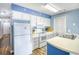 Bright kitchen featuring white appliances, countertops, and blue wall trim at 1210 N Ocean Blvd. # 202, Surfside Beach, SC 29575