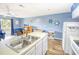 Open-concept kitchen and living area with stainless steel appliances, island sink, and seating at 1210 N Ocean Blvd. # 202, Surfside Beach, SC 29575