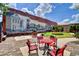 Charming outdoor space with a train mural on the brick wall and red table and chairs at 1220 Dunraven Ct., Conway, SC 29527