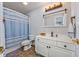 Bathroom featuring a vanity with storage, toilet, and shower with blue striped curtain at 136 Waterway Crossing Ct., Little River, SC 29566