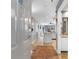 View through front door into condo's hall, leading to the modern kitchen with white island and wood floors at 161 Seawatch Dr. # 1101, Myrtle Beach, SC 29572