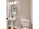 Bright bathroom featuring a pedestal sink, framed mirror and a toilet at 177 Azure Loop, Myrtle Beach, SC 29588