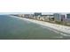 Extensive beach with people enjoying the day, condo buildings, and a partly cloudy sky at 200 76Th Ave. N # 510, Myrtle Beach, SC 29572