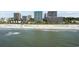Inviting ocean and beach with people, umbrellas, and condo buildings in the background at 200 76Th Ave. N # 510, Myrtle Beach, SC 29572