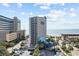 Stunning view of the oceanfront building, beach, and palms under a bright, partly cloudy sky at 200 76Th Ave. N # 510, Myrtle Beach, SC 29572