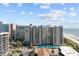 A stunning complex with a pool and balconies overlooks the beach with a vibrant, partly cloudy sky at 200 76Th Ave. N # 510, Myrtle Beach, SC 29572