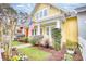 Charming yellow home with manicured landscaping, decorative flower pots, and an American flag at 203 Da Gullah Way # C, Pawleys Island, SC 29585