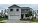 Two-story home features a two-car garage, gray siding and black shutters at 210 Bald Cypress Way, Conway, SC 29527