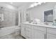 Bright bathroom with dual sink vanity, decorative tiling and combination tub and shower at 2557 Pete Dye Dr. # 403, North Myrtle Beach, SC 29582