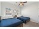 Bright bedroom featuring two beds with blue bedding and a decorative round mirror at 2557 Pete Dye Dr. # 403, North Myrtle Beach, SC 29582