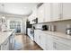The well-lit kitchen is equipped with stainless steel appliances, white cabinets, and a view of the outdoor balcony at 2557 Pete Dye Dr. # 403, North Myrtle Beach, SC 29582