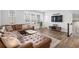 Well-lit living room with a brown leather couch, a wooden coffee table, and a view of a TV and the staircase at 2557 Pete Dye Dr. # 403, North Myrtle Beach, SC 29582