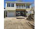 Charming stilt home with shingle siding, blue shutters, and spacious covered deck and garage at 328 46Th Ave. N, North Myrtle Beach, SC 29582