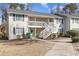 Exterior of a two-story condo featuring a white staircase and well-maintained landscaping at 3555 Highway 544 # 17F, Conway, SC 29526