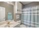 Bathroom with cabinet storage and a shower/tub combo with a striped curtain at 4179 Hibiscus Dr. # 303, Little River, SC 29566