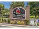 Decorative brick sign for The Gardens at Cypress Bay surrounded by manicured landscaping at 4179 Hibiscus Dr. # 303, Little River, SC 29566