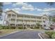 Inviting three-story condo building featuring multiple balconies and attractive landscaping at 4179 Hibiscus Dr. # 303, Little River, SC 29566