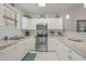 Bright kitchen boasts white cabinetry, granite countertops, stainless steel appliances, and tiled flooring at 4179 Hibiscus Dr. # 303, Little River, SC 29566
