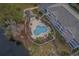 Aerial view of a kidney-shaped swimming pool surrounded by lounge chairs and tropical landscaping at 4179 Hibiscus Dr. # 303, Little River, SC 29566