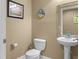 Quaint powder room features a pedestal sink, toilet, neutral paint, and decorative beach-themed accents at 4604 S Ocean Blvd. S # 1B, North Myrtle Beach, SC 29582