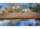 Spacious backyard of the home reflecting in pond, featuring a screened porch, patio, and mature landscaping at 470 Spring Lake Dr., Myrtle Beach, SC 29579