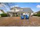 Expansive backyard with screened porch, patio seating, and inviting blue Adirondack chairs at 470 Springlake Dr., Myrtle Beach, SC 29579
