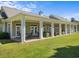 Inviting clubhouse patio with white columns, outdoor seating, and well-maintained landscaping at 4865 Luster Leaf Circle # 304, Myrtle Beach, SC 29577