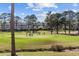 Scenic golf course view with players on the green, set against a backdrop of trees and condos at 4865 Luster Leaf Circle # 304, Myrtle Beach, SC 29577