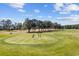 Picturesque golf course with players putting on the green surrounded by lush trees under a blue sky at 4865 Luster Leaf Circle # 304, Myrtle Beach, SC 29577