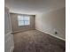 Bright bedroom with neutral carpet and walls, illuminated by natural light from a window at 5001 Little River Rd. # E-312, Myrtle Beach, SC 29577