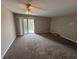 A cozy living room featuring soft carpet, a ceiling fan, and access to the outdoor balcony at 5001 Little River Rd. # E-312, Myrtle Beach, SC 29577