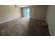 Open living space with neutral walls, plush carpeting, and a sliding glass door to a balcony at 5001 Little River Rd. # E-312, Myrtle Beach, SC 29577