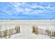 Picturesque beach entrance through a rustic fence with views of the serene ocean and expansive sandy shoreline at 5507 N Ocean Blvd. # 304, Myrtle Beach, SC 29577