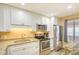 Well-lit kitchen featuring stainless steel appliances, granite countertops, and white cabinets at 5507 N Ocean Blvd. # 304, Myrtle Beach, SC 29577