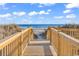 Wooden boardwalk to the beach with a clear view of the ocean under a bright blue sky at 5750 Oyster Catcher Dr. # 533, North Myrtle Beach, SC 29582