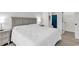 Well-lit bedroom features a plush bed with a white comforter and views into the attached bath at 5750 Oyster Catcher Dr. # 533, North Myrtle Beach, SC 29582