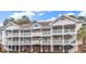 Attractive three-story condo building boasts multiple balconies with white railings and neutral color scheme at 5750 Oyster Catcher Dr. # 533, North Myrtle Beach, SC 29582