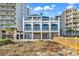 Beach house exterior with a sandy dune in front and a wooden walkway leading to the house at 5750 Oyster Catcher Dr. # 533, North Myrtle Beach, SC 29582