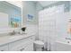 Bright bathroom features a vanity with a light countertop, and a tub with a shower and curtain at 6514 Anchors Bend Dr Sw, Ocean Isle Beach, NC 28469