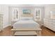 Bedroom featuring wood floors, large windows with shutters, and a queen size bed at 6514 Anchors Bend Dr Sw, Ocean Isle Beach, NC 28469